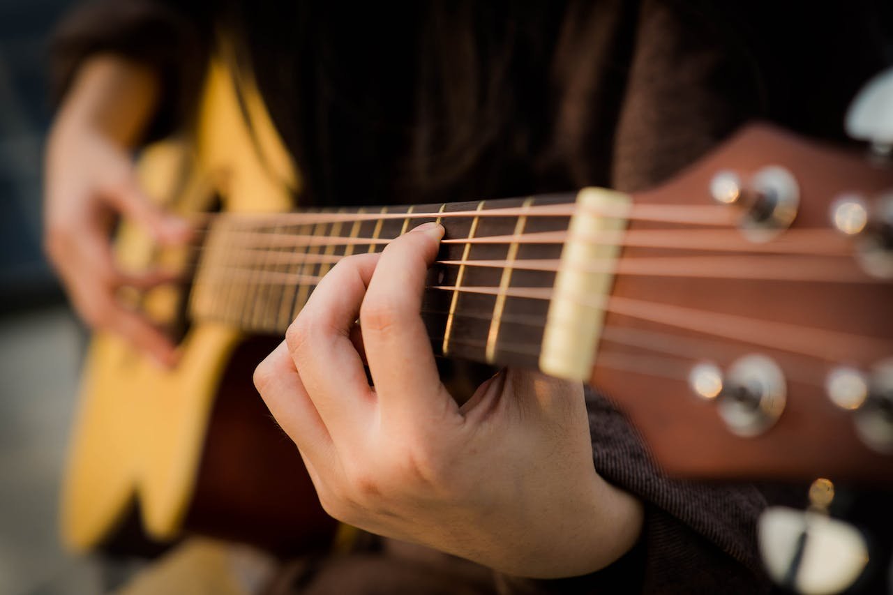 Close up of a guitarist playing chords on acoustic guitar